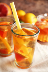 Iced tea with lemon and grapefruit on wooden background