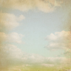 Old paper background with blue sky and white clouds in grunge style. 