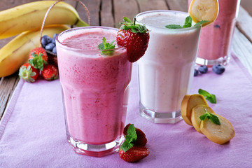 Glasses of fresh cold smoothie with fruit and berries, on the table, close-up