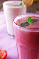 Glasses of fresh cold smoothie with fruit and berries, on the table, close-up