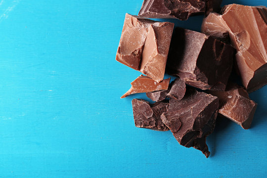 Dark And Milk Chocolate Pieces On Color Wooden Background