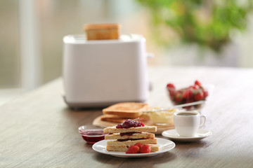 Served table for breakfast with toast and jam, on blurred background
