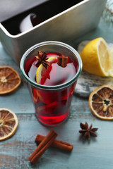Tasty mulled wine and spices, on blue wooden background, close-up