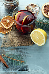 Tasty mulled wine and spices, on blue wooden background, close-up