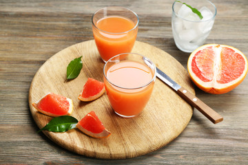 Citrus juice with ice and fresh fruits on cutting board