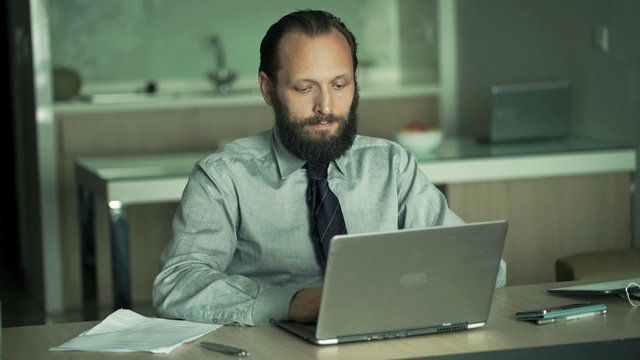 Young businessman working on laptop in office 
