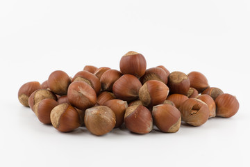 hill of hazelnuts in a shell lies on a white background