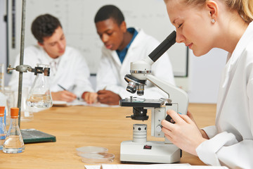 Teenage Students In Science Class Using Microscope