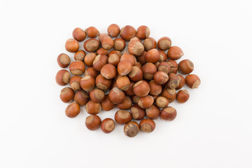 hill of hazelnuts in a shell lies on a white background