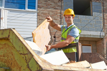 Builder Putting Waste Into Rubbish Skip