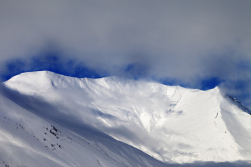 View on sunlight evening off-piste slope in mist