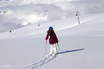 Fototapeta na wymiar Girl on skis in off-piste slope with new fallen snow at nice day