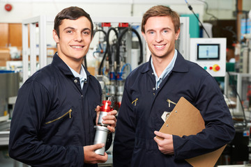 Portrait Of Engineer And Apprentice In Factory