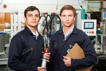 Portrait Of Engineer And Apprentice In Factory