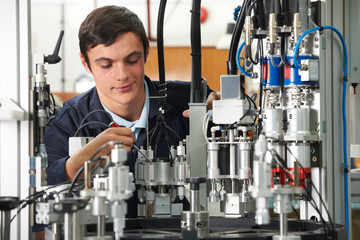 Apprentice Engineer Working On Machinery In Factory