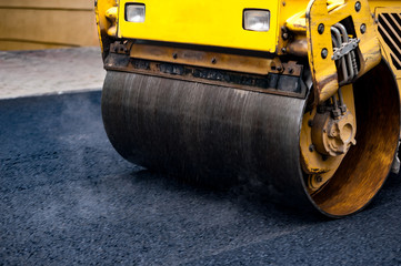 Compact steamroller flatten out the asphalt