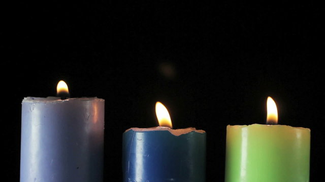 Three candles on black background