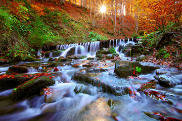 Beautiful waterfall in forest at sunset