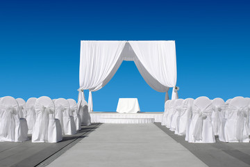 Obraz na płótnie Canvas Wedding canopy with chairs, all in white on blue sky