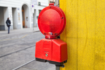 Red signal light on yellow construction area border