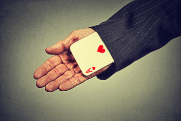 cropped image senior man hand pulling out a hidden ace from the sleeve