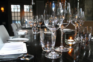 Fototapeten ansprechend gedeckter Tisch mit Weingläsern, Tellern und Besteck in einem Restaurant © Carmela