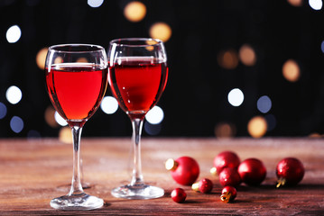 Wine glasses with Christmas decorations on wooden table