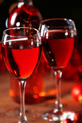 Wine glasses with Christmas decorations on wooden table, close up