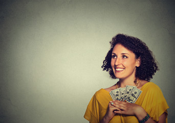 excited successful young business woman holding money dollar bills in hand