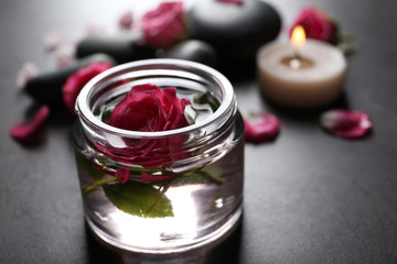 Spa composition of candles,  stones and flowers, on grey background