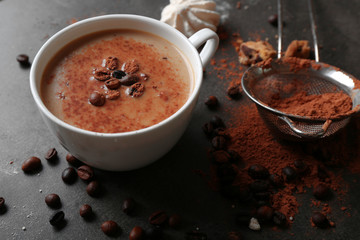 Cup of coffee and sweets on black wooden background