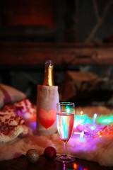Bottle of wine on white rug on dark background