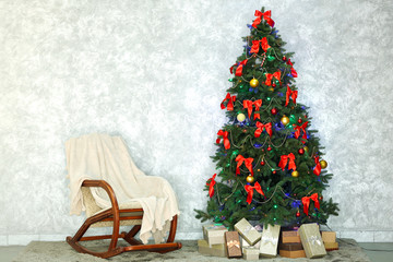 Decorated Christmas tree on light wall background