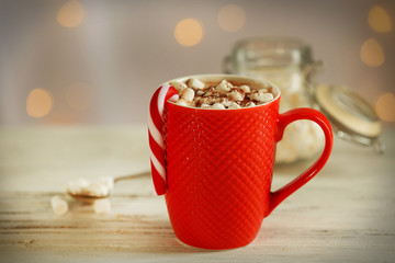 A cup of tasty cocoa and marshmallow on blurred background