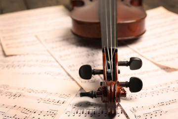 Naklejka premium Violin neck on music papers background