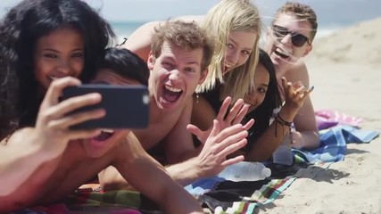 Group of young interracial friends taking selfie on the beach - Powered by Adobe