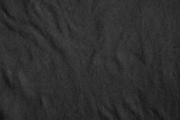 Black canvas with delicate striped pattern, crumpled.