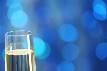 A glass of champagne on blue blurred background © Africa Studio