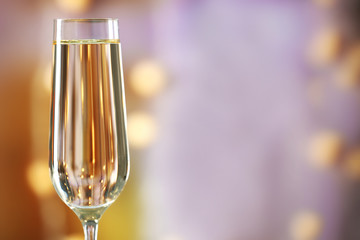 A glass of champagne on blurred lighted background