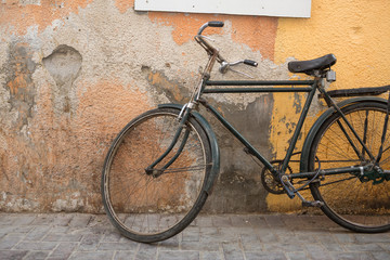 vintage workers bike leaning against colourful textured distressed wall