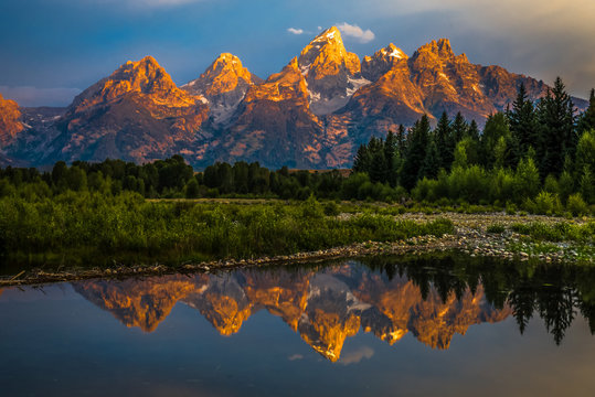 Fototapeta The dramatic colors of the Grand Teton Mountains reflecting in the water on a clear summer morning. 