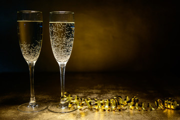 two glasses of champagne on a gold background. Christmas and New