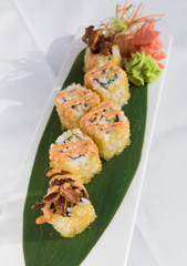 sushi covered in fish eggs served on a leaf