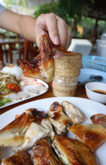 Picking roasted chicken by bare hands