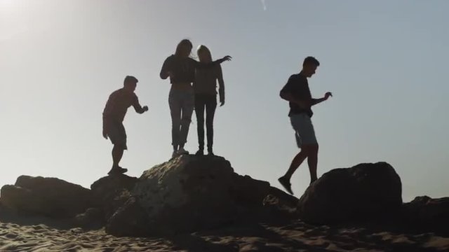 Friends exploring rocks at the beach