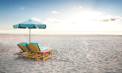 A pair of beach chair with umbrella in a seashore