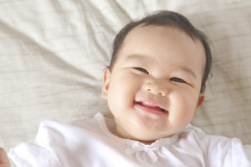 Asian Baby Girl Smiling and Looking to Mother.