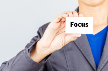 FOCUS,  message on the card held by a man hand
