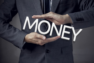 Businessman in suit with two hands in position to protect the wo