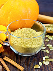 Flour pumpkin in glass cup with seeds on board